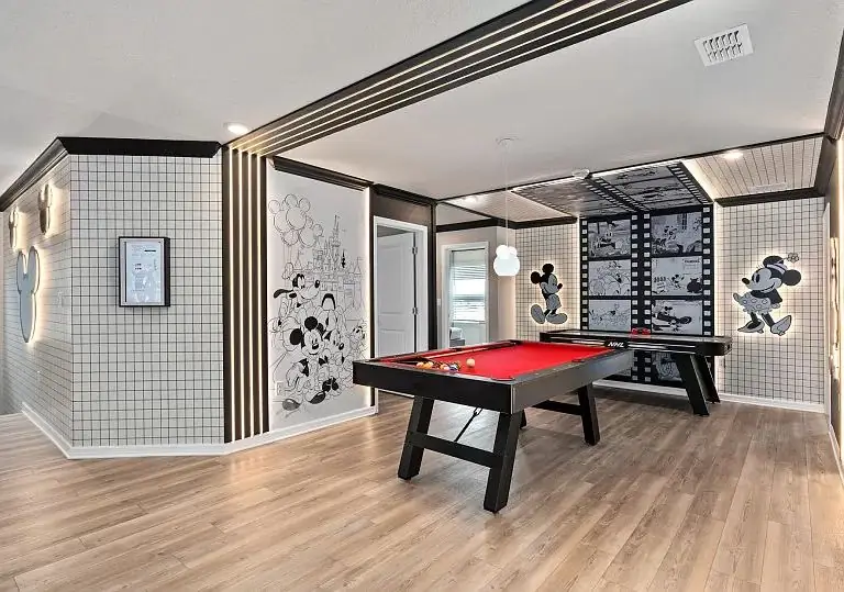 Sala de jogos com mesa de sinuca e tema Disney